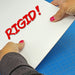Hands attempting to bend a thick 0.100-inch white styrene plasticard sheet to demonstrate the rigidity of the material, overlaid with the word "RIGID!" in red text.